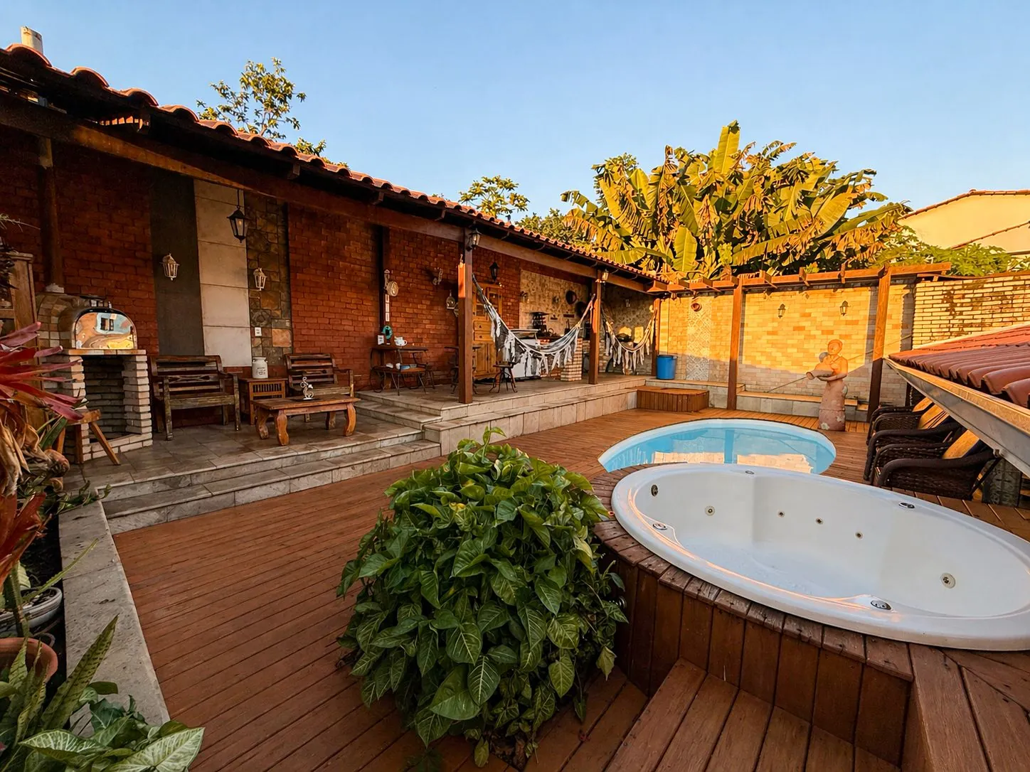 Área de lazer completa com deck, piscina, hidromassagem e churrasqueira