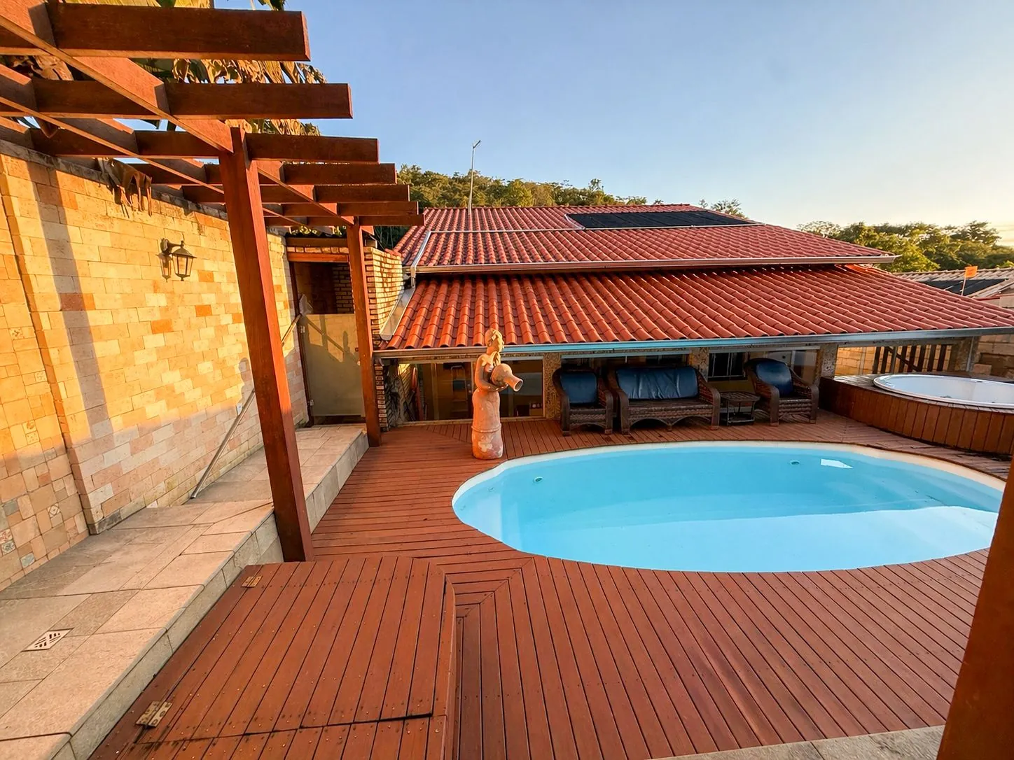 piscina com pergolado ao pôr do sol