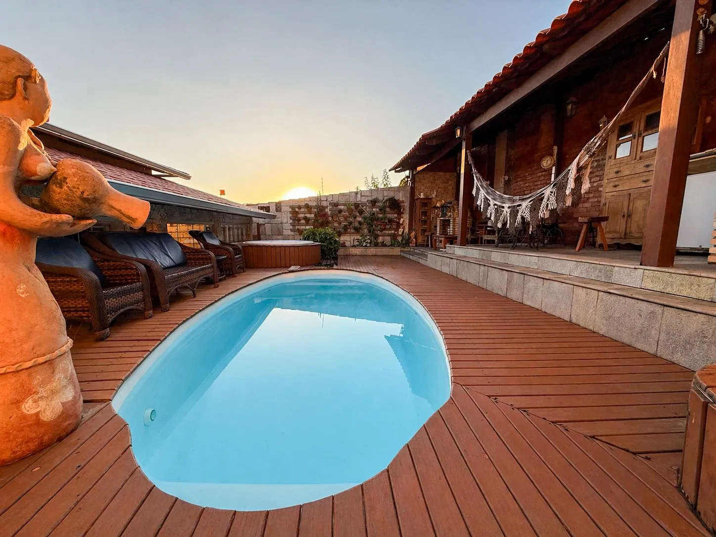 piscina aquecida ao pôr do sol com deck de madeira